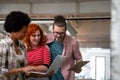 Smiling group of diverse businesspeople going over paperwork together, working in corporate office Royalty Free Stock Photo