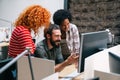 Smiling group of diverse businesspeople going over paperwork together, working in corporate office Royalty Free Stock Photo