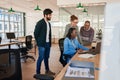 Smiling group of diverse businesspeople working together around a laptop Royalty Free Stock Photo