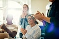 Smiling group of diverse coworkers clapping during an office presentation Royalty Free Stock Photo