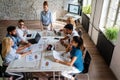 Smiling group of diverse businesspeople working together around a meeting table in an office Royalty Free Stock Photo