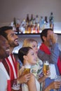 Smiling group of friends having beer while watching match Royalty Free Stock Photo