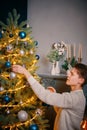 Smiling guy decorating Christmas tree. Royalty Free Stock Photo