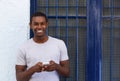 Smiling guy holding mobile phone outside Royalty Free Stock Photo