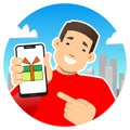 Smiling guy with a phone. Shows the phone screen, points to it with a finger. Gift, gift box with a bow on the screen.