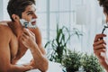 Smiling guy shaving his beard by razor Royalty Free Stock Photo