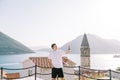 Smiling guy takes a selfie while standing on a platform overlooking the Bay of Kotor. Perast, Montenegro