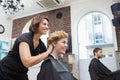 Smiling hairdresser chatting with customer