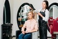 smiling hairdresser drying customer hair
