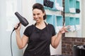 Smiling hairdresser holding hair equipment