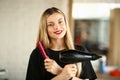 Smiling Hairstylist with Hairdryer and Round Comb