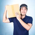 Smiling handsome asian delivery man giving and carrying parcel o