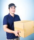 Smiling handsome asian delivery man giving and carrying parcel o Royalty Free Stock Photo