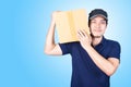 Smiling handsome asian delivery man giving and carrying parcel o Royalty Free Stock Photo