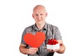 Smiling handsome bald middle-aged man hold big red paper heart and white gift box with red ribbon bow isolated on white Royalty Free Stock Photo