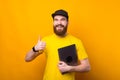 Smiling handsome bearded man showing thumb up and holding laptop Royalty Free Stock Photo