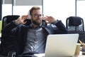 Smiling handsome businessman relaxing and listening music in earphones in a modern office Royalty Free Stock Photo