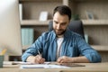 Smiling Handsome Businessman Taking Notes To Notepad At Workplace In White Office Royalty Free Stock Photo