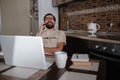 Smiling handsome freelancer working remotely from home. He is speaking on the phone Royalty Free Stock Photo