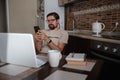 Smiling handsome freelancer working remotely from home. He is speaking on the phone Royalty Free Stock Photo