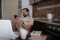 Smiling handsome freelancer working remotely from home. He is speaking on the phone Royalty Free Stock Photo