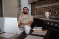 Smiling handsome freelancer working remotely from home. He is speaking on the phone Royalty Free Stock Photo