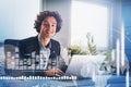 Smiling handsome Hispanic businessman working on laptop to develop trading strategy. Concept of analyzing stock market behavior.