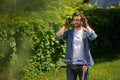 Smiling handsome male gardener putting safety glasses before mowing overgrown lawn at day.