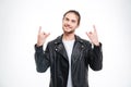 Smiling handsome man in black leather jacket doing rock gesture Royalty Free Stock Photo