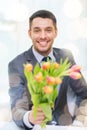 Smiling handsome man giving bouquet of flowers