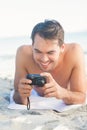 Smiling handsome man lying on his towel looking at his camera Royalty Free Stock Photo