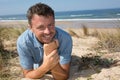 Smiling handsome man relaxing on the beach lying on sand Royalty Free Stock Photo