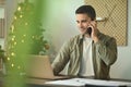 Handsome man using laptop computer and talking on mobile phone. Royalty Free Stock Photo