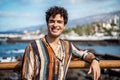 Smiling handsome spanish young man looking at the camera. Fashionable hipster. Sunny summer day. Traveler Royalty Free Stock Photo