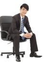 Smiling and handsome Young business man sitting on a chair Royalty Free Stock Photo