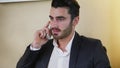 Smiling handsome young businessman at desk on phone Royalty Free Stock Photo