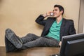 Smiling handsome young businessman at desk on phone Royalty Free Stock Photo