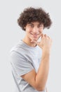 Smiling and handsome a young man with curly hair he looks into the camera with his blue eyes, his hands on his face, a portrait of Royalty Free Stock Photo