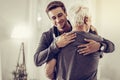 Smiling handsome young man embracing grey-haired dad cheering him up