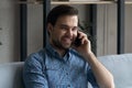 Smiling handsome young man involved in pleasant smartphone conversation. Royalty Free Stock Photo