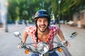 Smiling handsome young man riding scooter Royalty Free Stock Photo