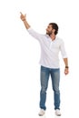 Smiling Handsome Young Man Is Standing With Arm Raised, Pointing Up And Looking Away Royalty Free Stock Photo