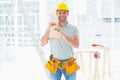 Smiling handyman carrying planks in building