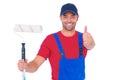 Smiling handyman with paint roller gesturing thumbs up