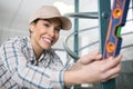 smiling handywoman using spirit level