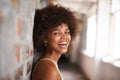 Smiling happily. Cropped portrait of an attractive young woman leaning against a brick wall. Royalty Free Stock Photo