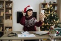 Smiling happy adult businesswoman in Santa hat doing selfie Royalty Free Stock Photo
