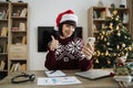 Smiling happy adult in Santa hat showing thumb up gesture Royalty Free Stock Photo