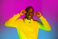 Smiling happy African handsome man posing isolated over gradient magenta yellow neon background.