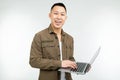Smiling happy asian man holding a laptop in his hands on a white studio background Royalty Free Stock Photo